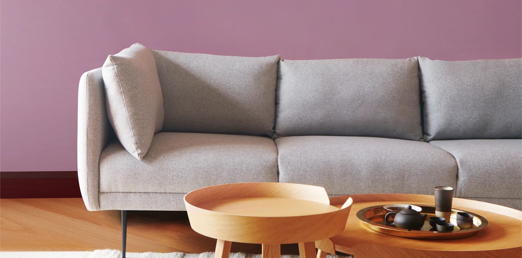 Mảng tường Berry Pink phía sau sofa xám