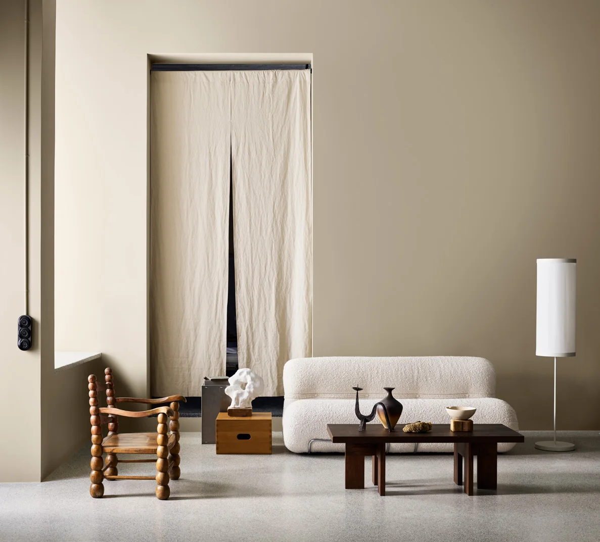 Phòng khách với tường be cát, sofa sáng và nội thất tối giản