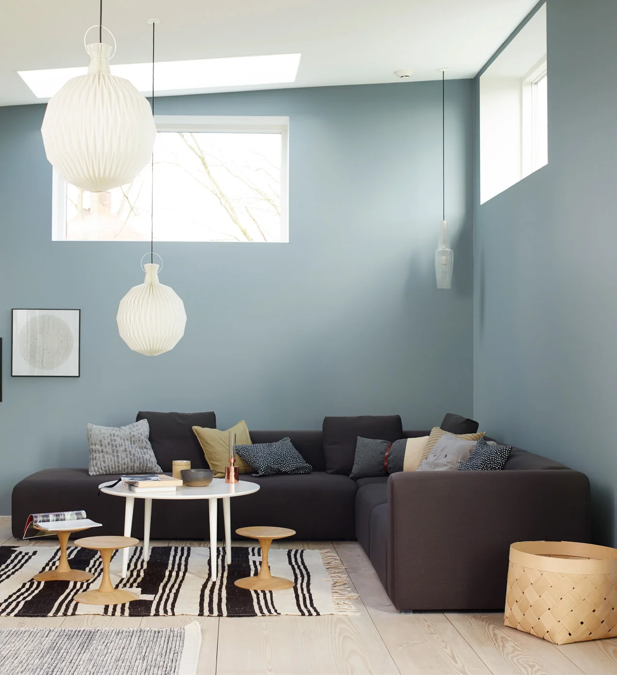 Phòng khách xanh xám nhạt với sofa tối màu