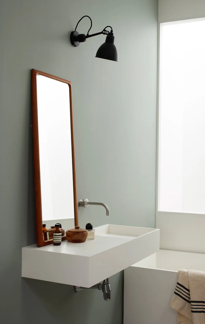 Phòng tắm xanh xám nhạt với gương đứng và lavabo trắng