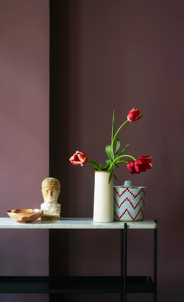 Bàn trang trí với bình hoa trên nền tường Dusty Purple